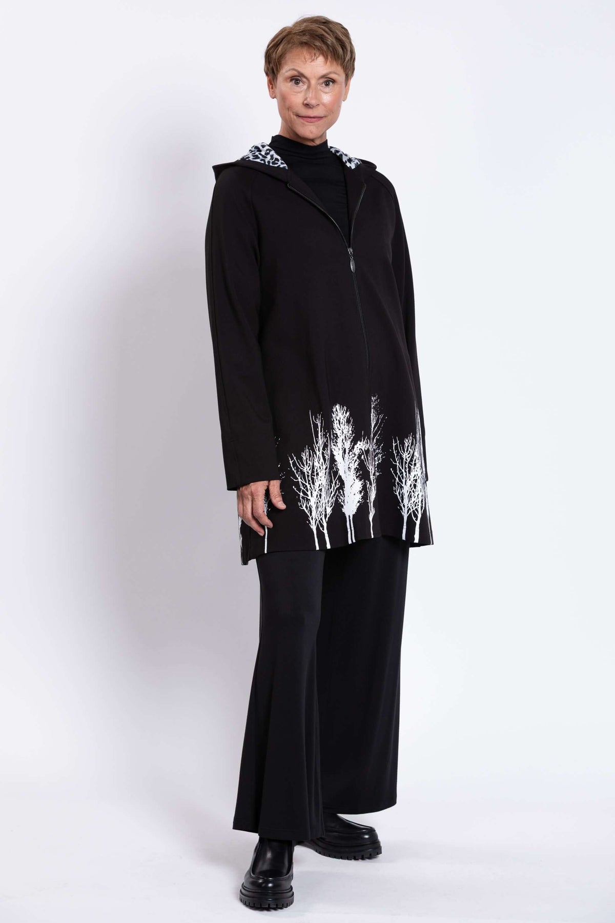 Three-quarter front view of Edith Coat displaying zip and tree border details