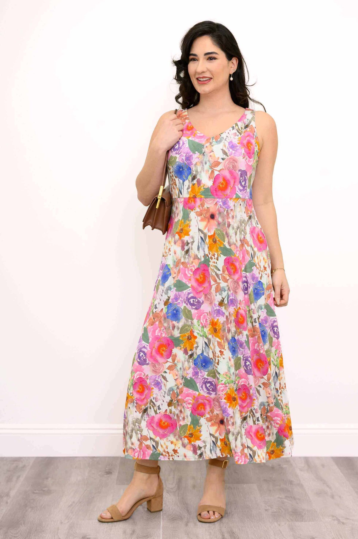 Three-quarter front view of woman modeling a colorful floral maxi dress