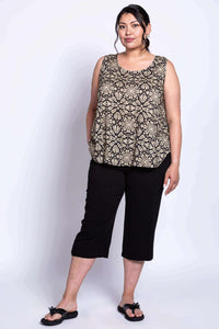 Three-quarter front view of model in black floral tank top with hands in pockets