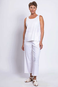 Three-quarter front view of woman in white linen tank top and pants