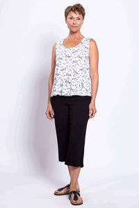 Three-quarter front view of woman modeling white floral peplum tank top