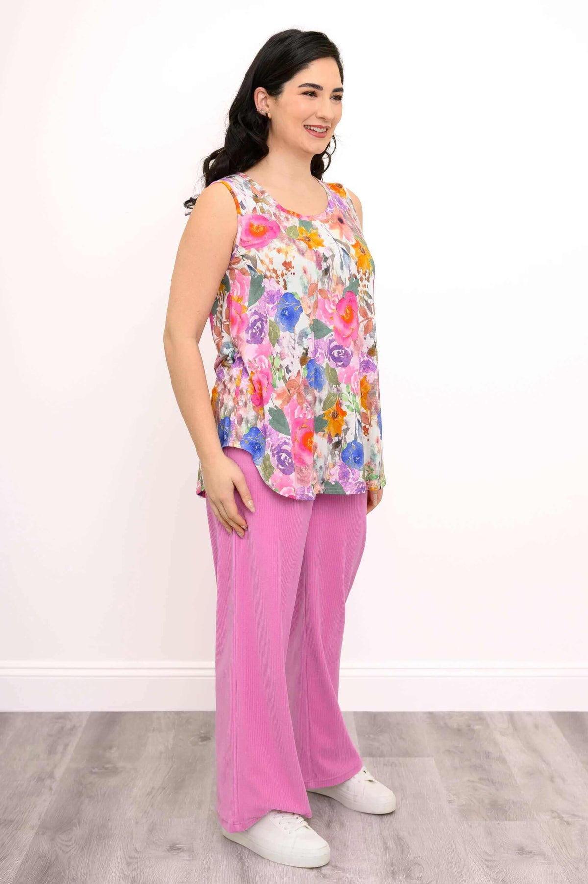 Three-quarter view of model in floral bamboo tank top and pink pants
