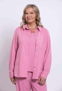 Three-quarter front view of a woman in a pink relaxed shirt with breast pocket