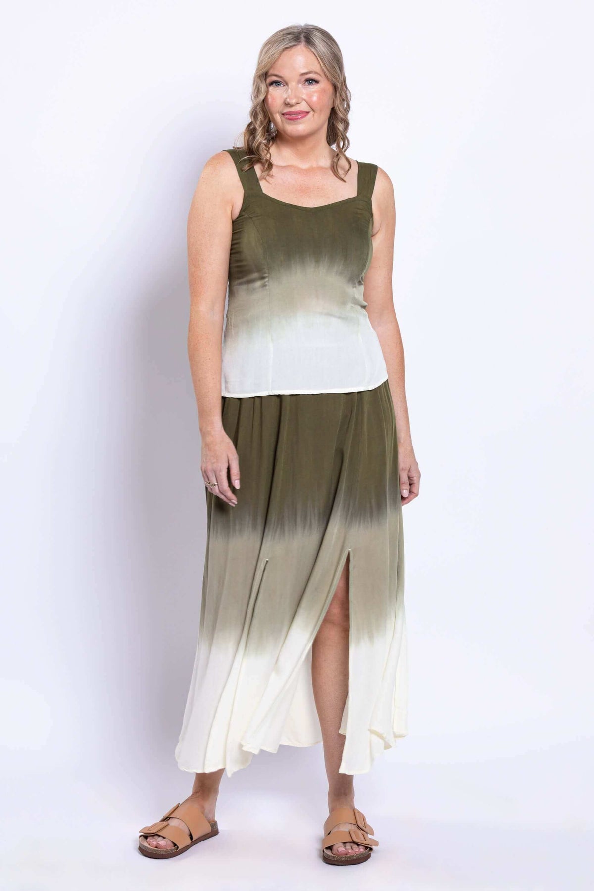 Three-quarter view of model in olive ombre tank top and skirt with leg slit