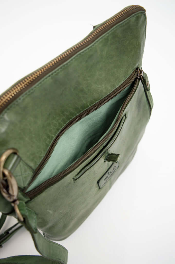 Top angled view into green crossbody bag with open exterior zipper pocket
