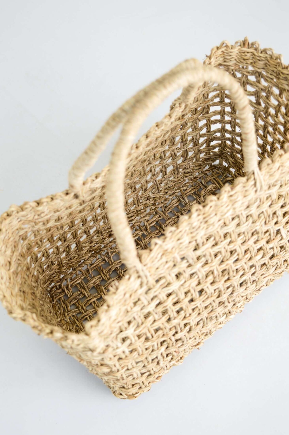 Top angle of open hand woven rattan basket showing its spacious interior