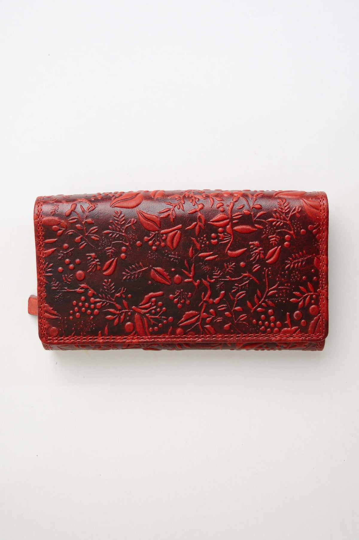 Top view of a closed red floral embossed leather wallet