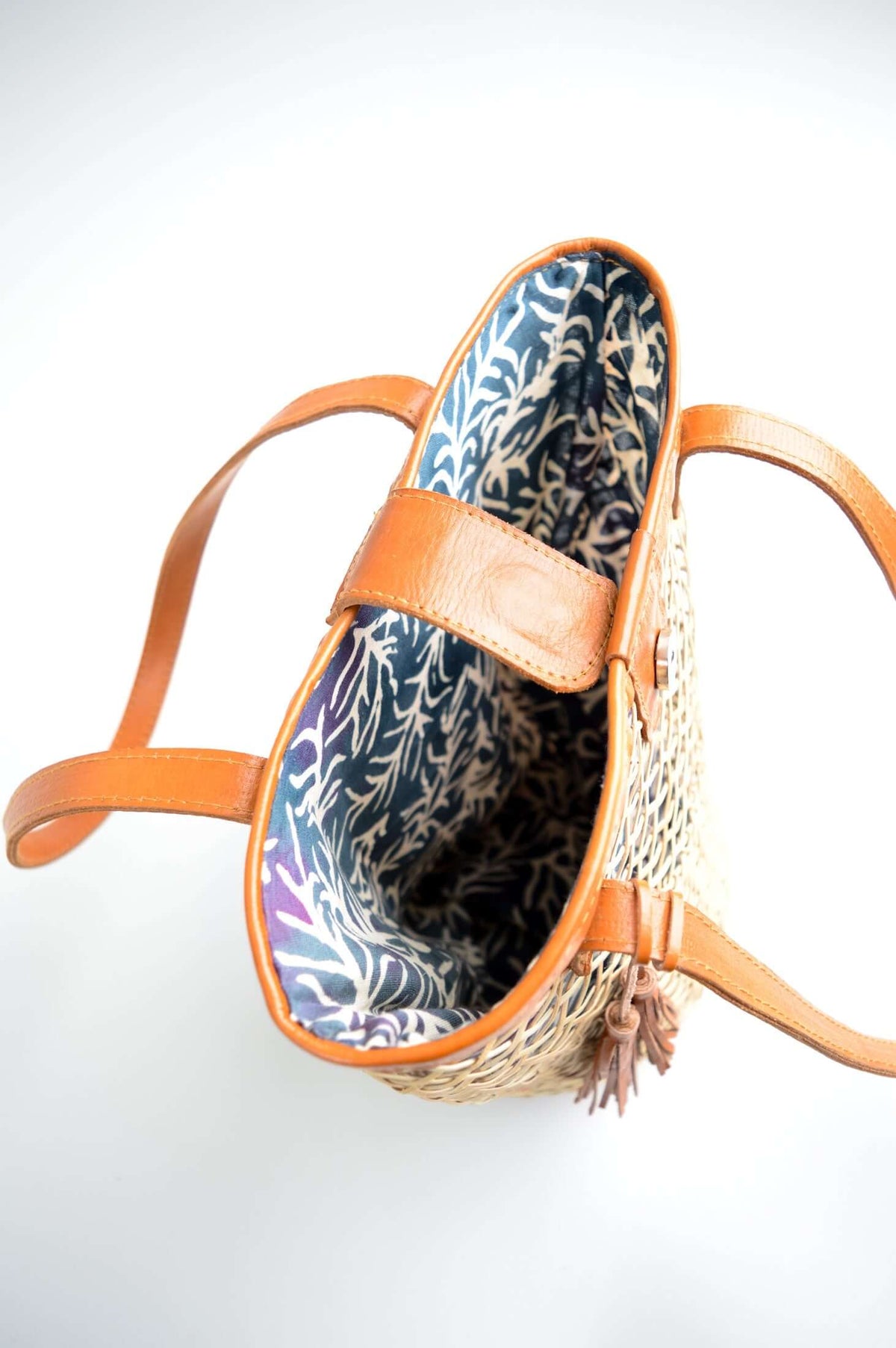Top view showing blue printed interior lining of rattan basket with leather trim