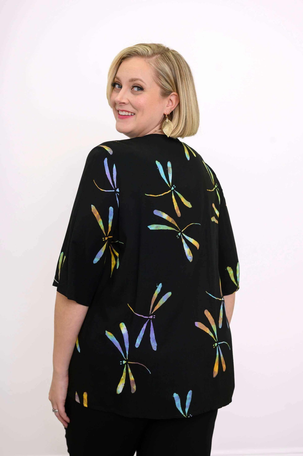 Back view of a woman displaying the dragonfly pattern on the Toucan Jacket