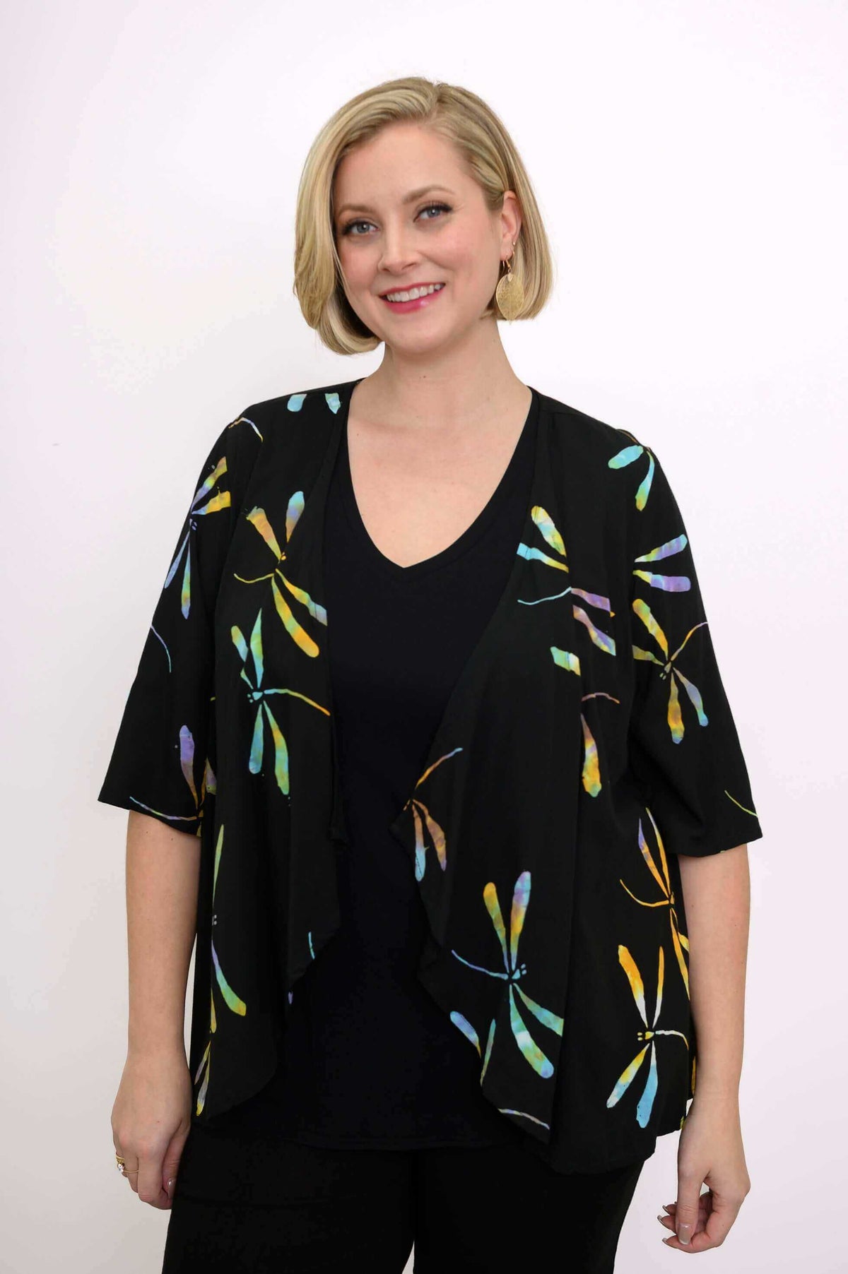 Front view of a woman wearing the black Toucan Jacket with colorful dragonfly print