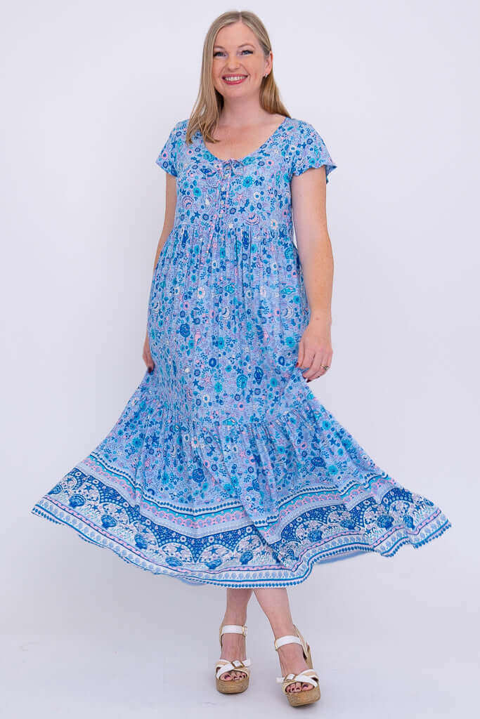 Woman twirling in blue floral maxi dress showing the skirt's movement