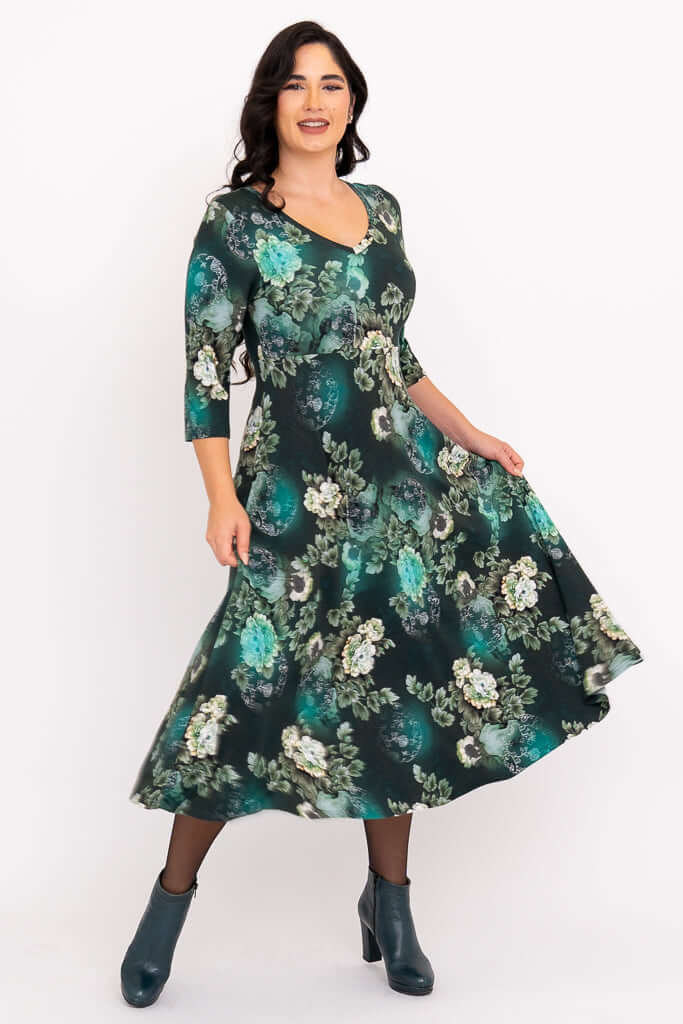 Woman twirling in emerald floral midi dress with V-neck and flowy skirt