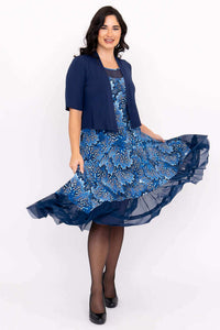 Woman twirling in blue floral dress with blue bolero and mesh hemline