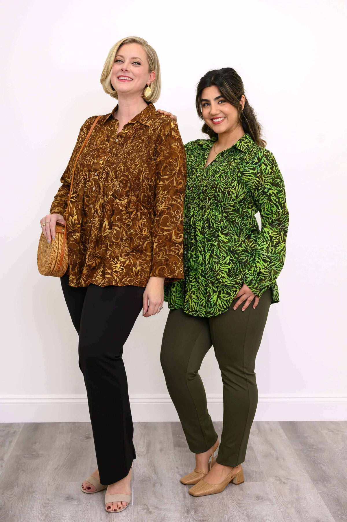 Two women wearing Cindy smocked tops in green and brown leaf prints
