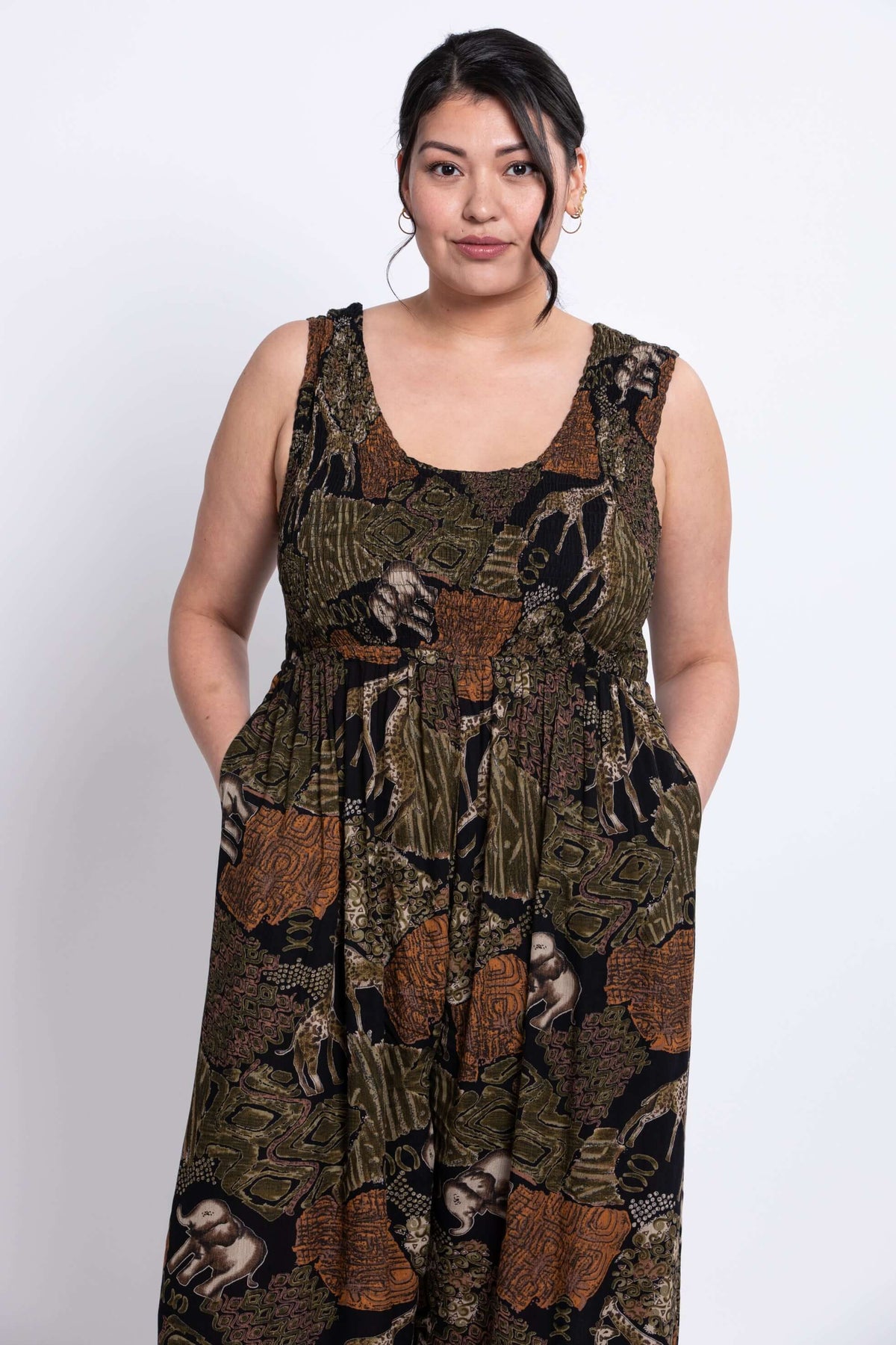 Model showing upper body and side pockets of a patterned safari jumpsuit