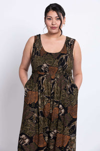 Model showing upper body and side pockets of a patterned safari jumpsuit