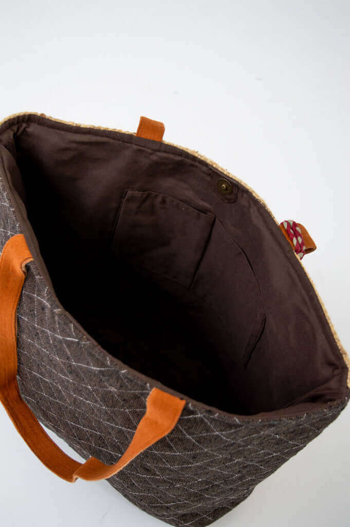 View inside the tote bag showing spacious pockets and magnetic closure