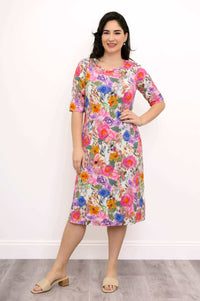 Woman posing in a bright multicolored floral bamboo dress with hands on hip