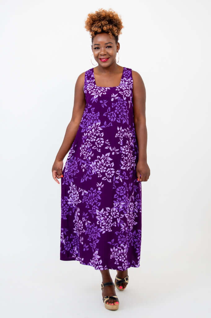 Model walking in a purple floral sleeveless maxi dress with flower pattern