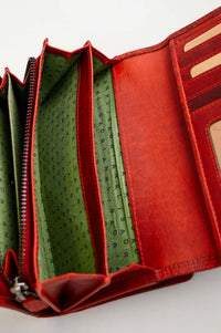 Interior compartments of a red leather wallet with green lining and card slots