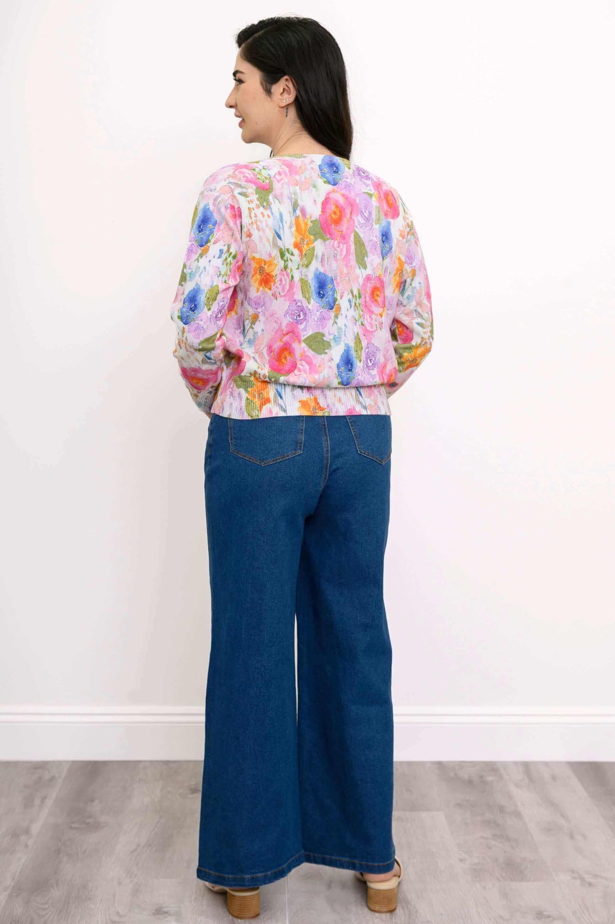 Back view of a woman wearing a watercolor floral cotton cardigan