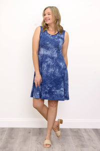 Front view woman wearing sleeveless blue tie dye short dress and sandals on a white background