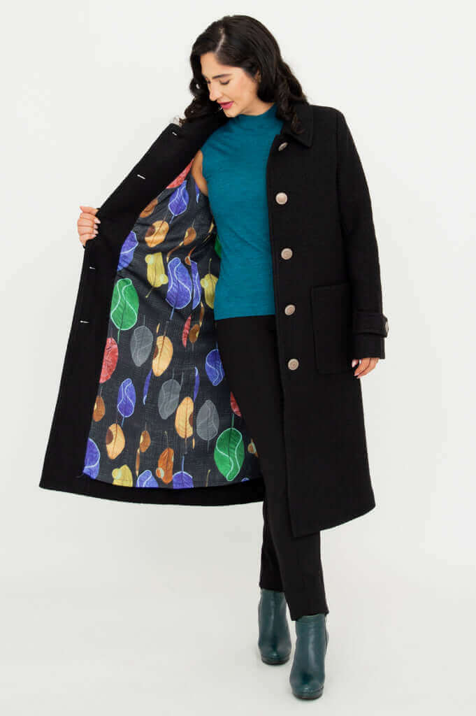 Woman displaying colorful printed lining inside the black Edna coat