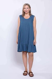 Woman modeling a sleeveless blue dress with ruffle hem, standing front-facing