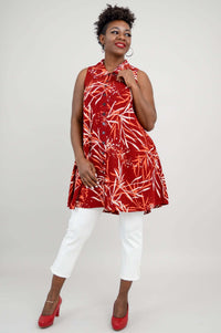 Woman playfully holding the collar of a sleeveless red bamboo print tank