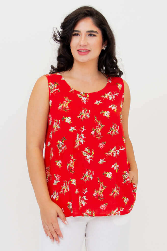 Woman wearing a red floral sleeveless tank top with white pants