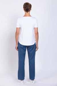 Full body back view of woman modelling white tee and tencel denim pants