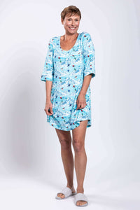 Woman smiling and displaying blue bamboo sleepshirt with mountain print