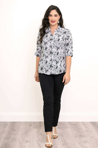 Woman in a floral bamboo-linen blouse standing with white heeled sandals