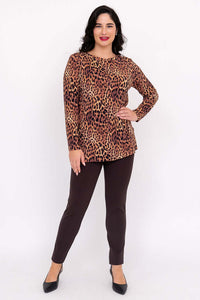 Woman in a relaxed pose showing off leopard print tunic top and dress pants