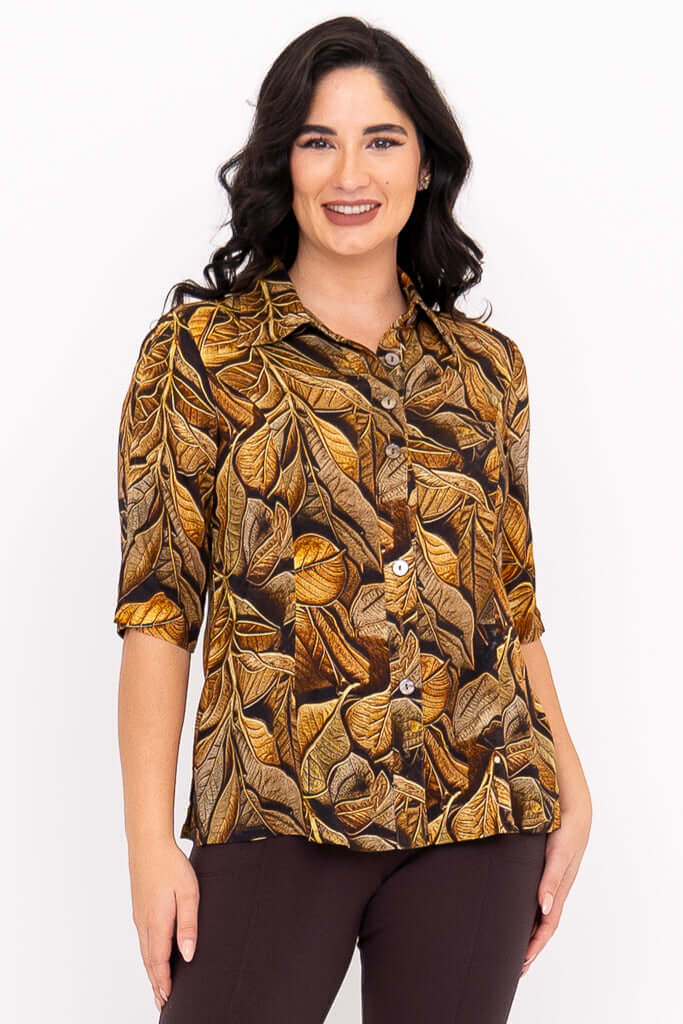 Woman wearing a button-down blouse with an autumn leaf print and elbow-length sleeves