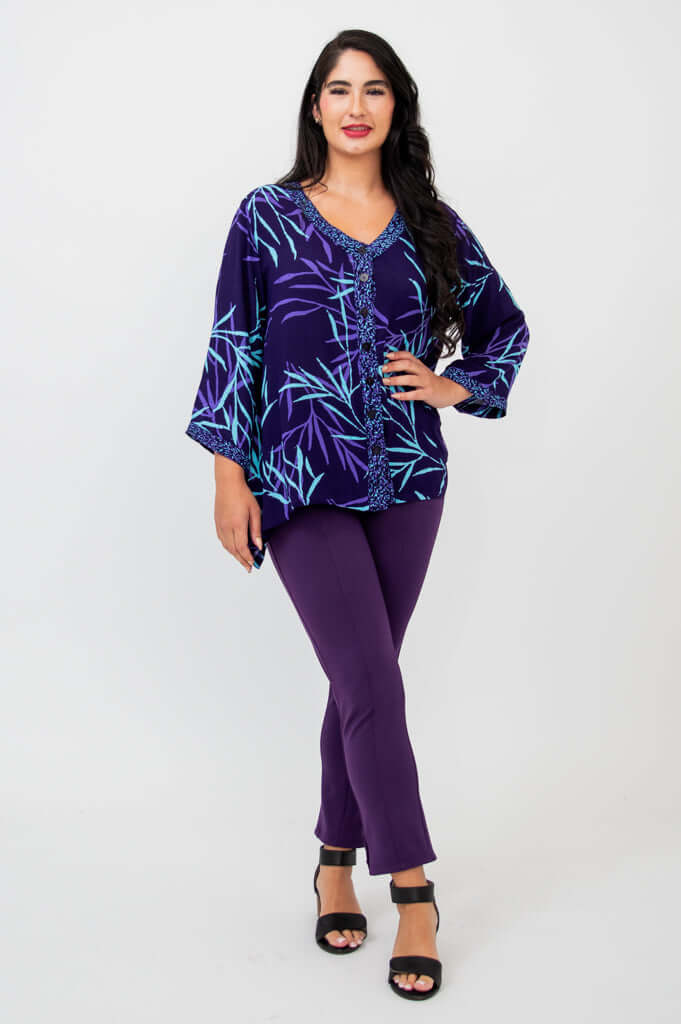 Woman posing in purple bamboo print tunic top and pants, hand on hip