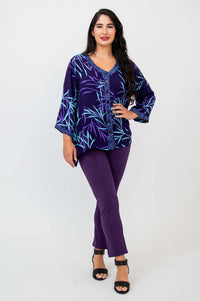 Woman posing in purple bamboo print tunic top and pants, hand on hip