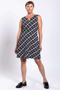 Woman posing in black and white plaid sleeveless shift dress, facing forward