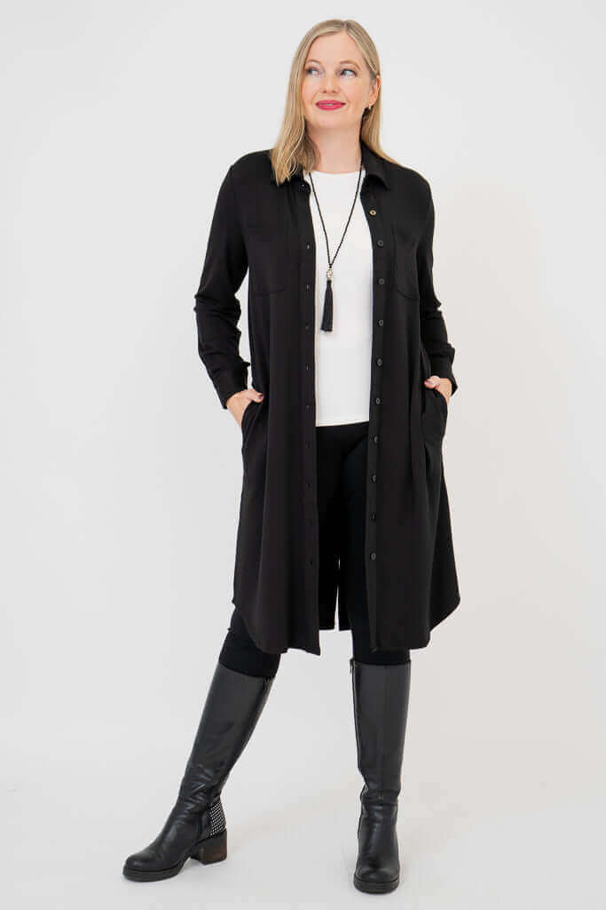 Woman in black bamboo duster, posing with hands in pockets and looking to the side