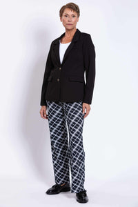Woman standing in black blazer and checked pants, front angle view