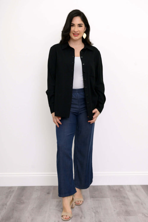 Woman wearing a black button-up shirt with blue wide-leg pants and beige heels