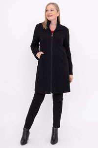 Woman in black shaped seam coat, styled with black pants and boots