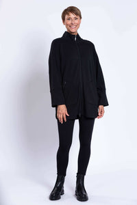 Woman standing in a black jacket and leggings, showing front and side