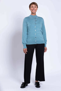 Woman in blue cardigan and black pants with relaxed fit and shiny black shoes