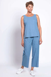 Woman wearing blue barrel-leg cropped pants and matching sleeveless top, front angled stance