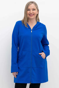Woman wearing a bright blue hooded jacket with front zipper and kangaroo pockets, smiling