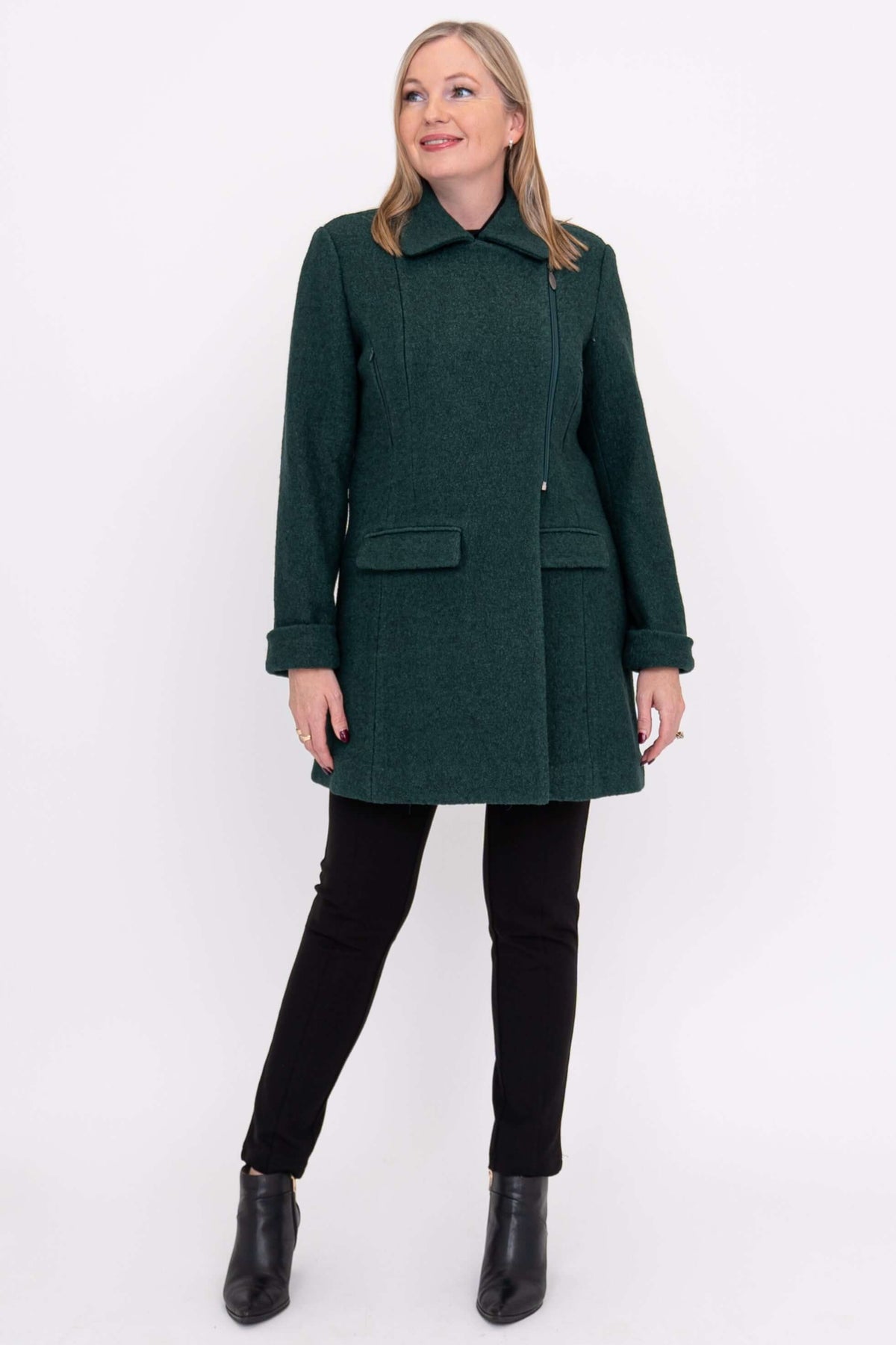 Woman wearing a dark green wool coat, looking upward