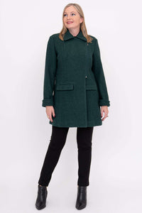 Woman wearing a dark green wool coat, looking upward