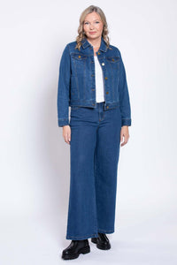 Front view of woman in blue denim jacket, white top, and wide-leg jeans