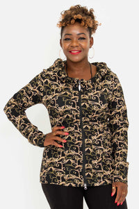 Woman wearing a fitted hooded jacket with gold vine print, zipped up